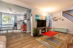 Open-concept living space with wood-finish flooring throughout - 