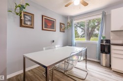 Dining area with wood-finish flooring and a large window overlooking a green landscape - 