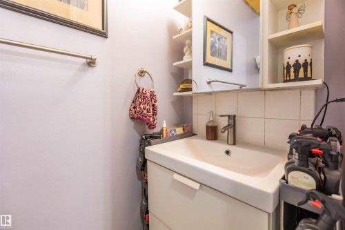 White vanity with integrated sink, chrome-finish faucet, and coordinating wall-mounted towel rings - 13323 47 Street Nw, Edmonton, AB - Indoor Photo Showing Bathroom