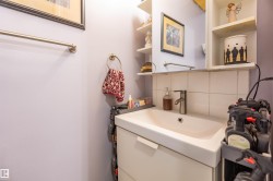 White vanity with integrated sink, chrome-finish faucet, and coordinating wall-mounted towel rings - 