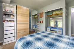 Built-in wardrobe with wood-finish and mirrored sliding doors, complemented by an open shelving unit with integrated drawers - 