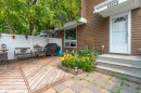 Expansive outdoor living area featuring a wooden deck and checkered paver patio - 13323 47 Street Nw, Edmonton, AB  - Outdoor With Deck Patio Veranda With Exterior 