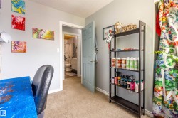 Carpeted room with light gray walls, white trim, and a light blue paneled door - 