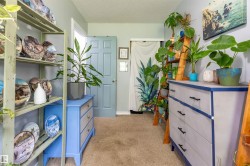 Carpeted interior space featuring light blue paneled doors, light-colored walls, and white trim - 