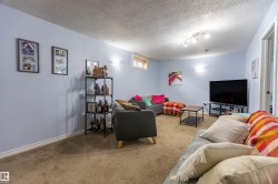 Carpeted recreation room featuring light blue walls, a white trim, and a small horizontal window - 
