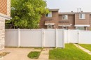 Private outdoor space featuring a white vinyl fence with gate, concrete patio, and grass area - 13323 47 Street Nw, Edmonton, AB  - Outdoor 