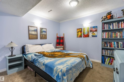 Bedroom featuring light blue walls, crown molding, and textured carpet flooring - 13323 47 Street Nw, Edmonton, AB - Indoor Photo Showing Bedroom