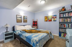 Bedroom featuring light blue walls, crown molding, and textured carpet flooring - 
