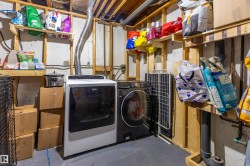 Dedicated laundry area featuring a white top-load washing machine and a black front-load dryer - 