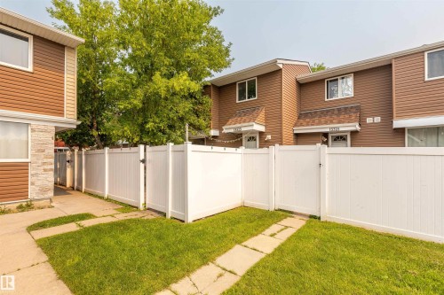 Private fenced yard space featuring a white vinyl fence and a concrete path - 13323 47 Street Nw, Edmonton, AB - Outdoor