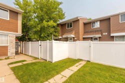 Private fenced yard space featuring a white vinyl fence and a concrete path - 