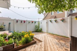 Expansive outdoor decking area featuring a multi-level design and a raised garden bed with established plantings - 