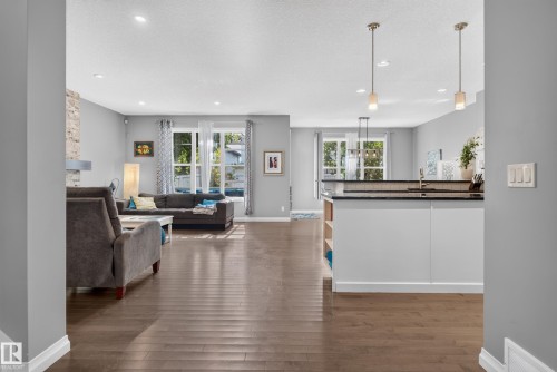 Wood-finish flooring, recessed lighting, and large windows with white trim - 22933 94A Avenue Nw, Edmonton, AB 