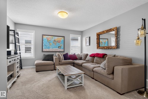 Carpeted interior with light gray walls, multiple windows with blinds, and a flush mount ceiling light fixture - 22933 94A Avenue Nw, Edmonton, AB 