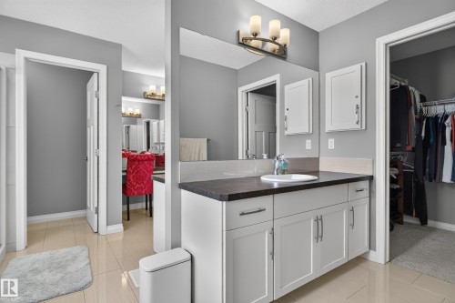 Vanity with white shaker cabinetry, dark countertop, and an undermount sink - 22933 94A Avenue Nw, Edmonton, AB 