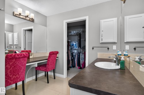 Vanity with integrated sink, dual wall-mounted medicine cabinets, built-in dressing table, and overhead lighting fixture - 22933 94A Avenue Nw, Edmonton, AB 