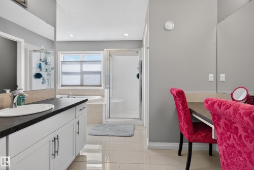 Bathroom featuring a dual vanity, built-in makeup desk, walk-in shower, and a large soaking tub - 22933 94A Avenue Nw, Edmonton, AB 