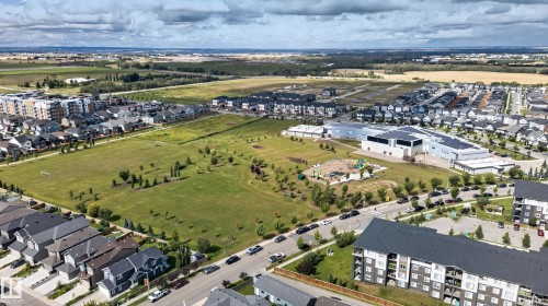 Expansive green space and a modern community building are central features in this developed neighborhood, surrounded by contemporary residences - 22933 94A Avenue Nw, Edmonton, AB 