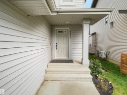 Entry with light-toned siding and a covered porch - 
