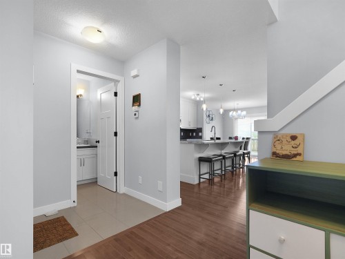 Tile flooring entry with wood-finish flooring extending into the living area - 6656 Cardinal Rd Sw, Edmonton, AB 