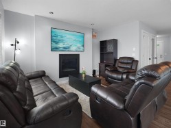 Recessed ceiling lighting, a contemporary fireplace, and a light gray wall finish - 