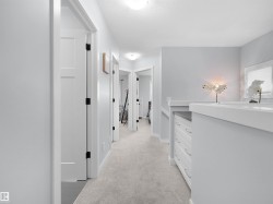Plush carpet flooring, recessed lighting, and white paneled doors with matte black hardware - 