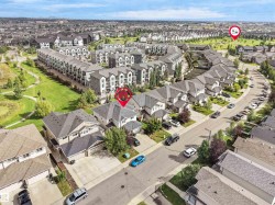 Residential neighborhood with varied housing styles including single-family homes and multi-story townhomes, surrounded by green spaces and paved roadways - 