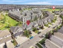 Residential neighborhood with varied housing styles including single-family homes and multi-story townhomes, surrounded by green spaces and paved roadways - 6656 Cardinal Rd Sw, Edmonton, AB 