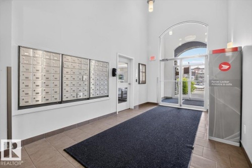 Secured entrance featuring individual mailboxes and parcel locker for resident convenience - #316 392 Silver Berry Rd Nw, Edmonton, AB - Indoor Photo Showing Other Room