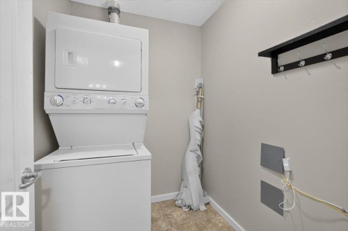 Dedicated laundry area featuring a stacked white washer and dryer unit - #316 392 Silver Berry Rd Nw, Edmonton, AB - Indoor Photo Showing Laundry Room