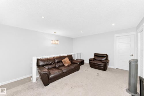 White interior walls with recessed lighting and a contemporary chandelier - 2628 Donaghey Crescent Sw, Edmonton, AB 