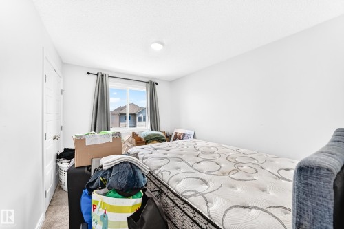 Window with dark drapery panels, flush mount ceiling lighting, and light-toned carpeting - 2628 Donaghey Crescent Sw, Edmonton, AB 