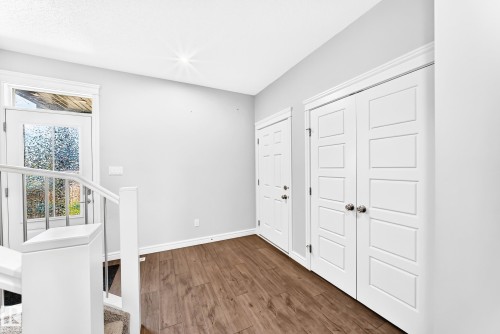 Wood-finish flooring, white paneled doors, white trim, and a glass-paneled exterior door - 2628 Donaghey Crescent Sw, Edmonton, AB 
