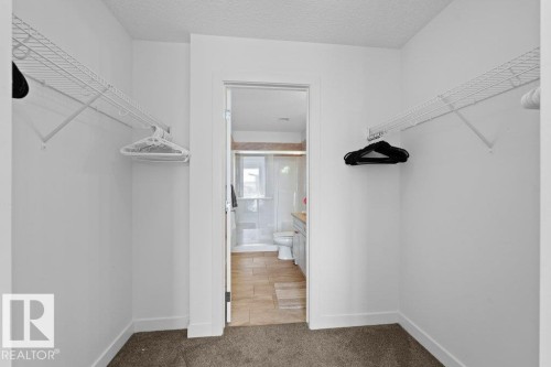 Walk-in closet with wire shelving and plush carpet flooring - 1316 Windermere Way Sw, Edmonton, AB 