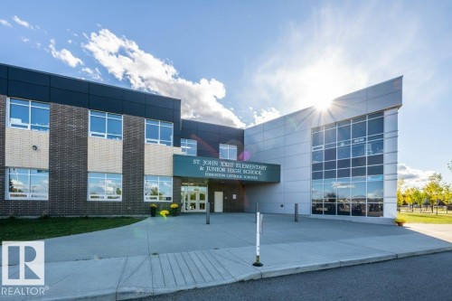 Modern institutional building featuring a multi-textured facade with brick, dark paneling, and light-toned metal siding - 1316 Windermere Way Sw, Edmonton, AB 
