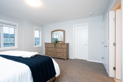 Bright interior with two windows, light gray walls, white trim, and neutral carpeting - 9232 224 St Nw Nw, Edmonton, AB 