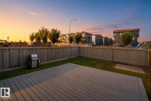 Expansive private yard featuring a wood-finish fence, composite decking, and a grass lawn - 9232 224 St Nw Nw, Edmonton, AB 