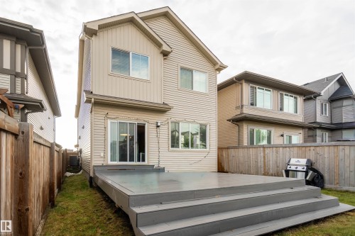 Two-story exterior with vinyl siding, featuring a multi-level wooden deck with steps, and sliding glass doorsAI - 9232 224 St Nw Nw, Edmonton, AB 