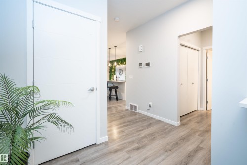 Light wood-finish flooring extending throughout, white interior doors, and modern wall-mounted thermostats - 9232 224 St Nw Nw, Edmonton, AB 