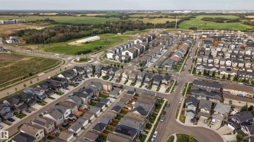 Expansive residential development featuring a variety of single-family homes and townhomes, curvilinear street layouts, and central roundabout - 9232 224 St Nw Nw, Edmonton, AB 