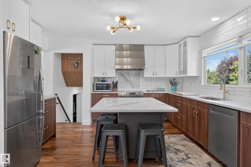 Modern kitchen with stainless steel appliances, white quartz countertops, wood-finish flooring, and white subway tile backsplash - 18316 71 Avenue Nw, Edmonton, AB 