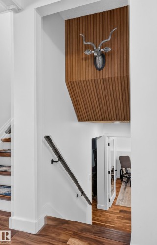 Wood-finish flooring, white walls, and a wood-slat accent wall - 18316 71 Avenue Nw, Edmonton, AB 