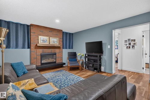 Brick-faced fireplace with a wood mantel and black hearth - 18316 71 Avenue Nw, Edmonton, AB 