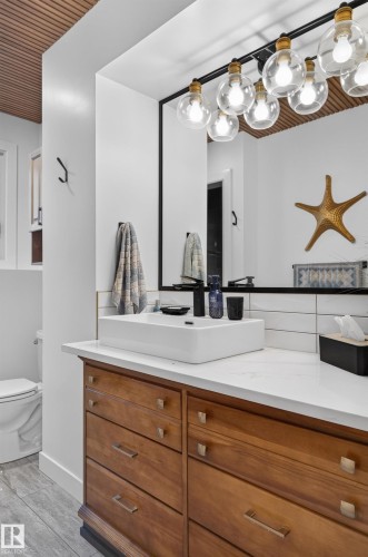 Custom vanity with wood-finish drawers, white countertop, and vessel sink - 18316 71 Avenue Nw, Edmonton, AB 