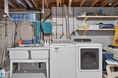 Double basin utility sink with a faucet, white washer, and white dryer - 18316 71 Avenue Nw, Edmonton, AB 