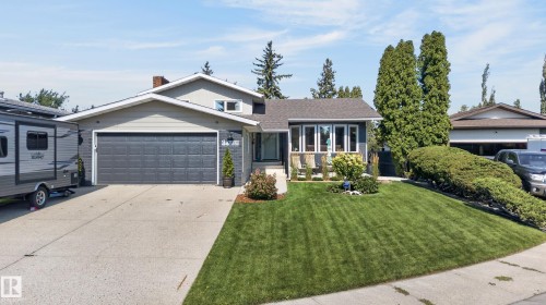Split-level residence featuring a gray exterior siding and a dark shingled roof - 18316 71 Avenue Nw, Edmonton, AB 