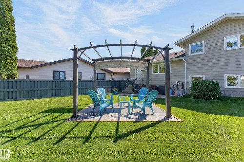 Expansive green lawn with a patio area and an arched pergola - 18316 71 Avenue Nw, Edmonton, AB 