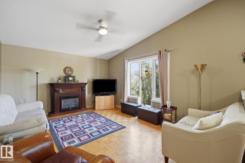 Vaulted ceilings, wood-finish parquet flooring, and a decorative fireplace with a wood mantel - 5132 157 Avenue Nw, Edmonton, AB 