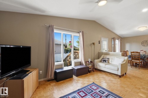 Vaulted ceilings, wood-finish flooring, and a large window with exterior access - 5132 157 Avenue Nw, Edmonton, AB 