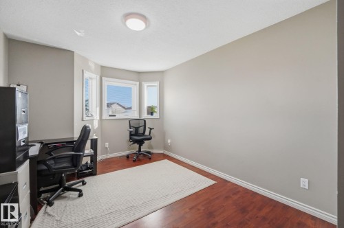 Hardwood-style flooring, light neutral wall tones, multi-pane window, and overhead flush-mount lighting - 5132 157 Avenue Nw, Edmonton, AB 